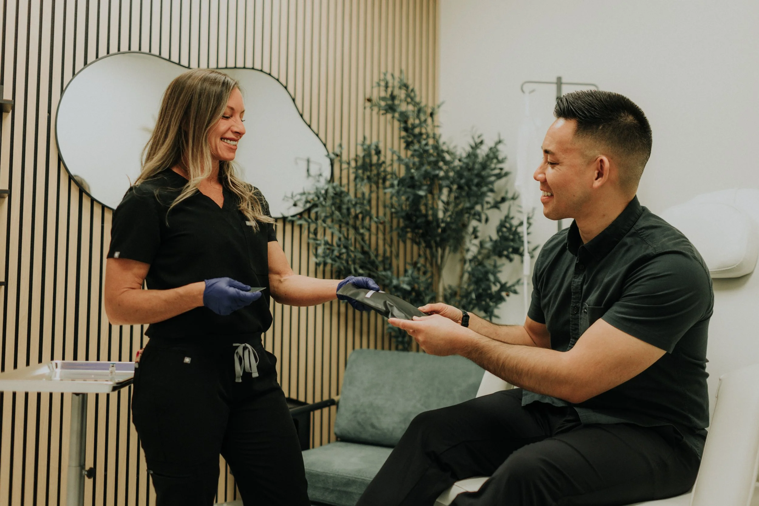 Erica Santana in scrubs smiling with a client in the FloState treatment chair