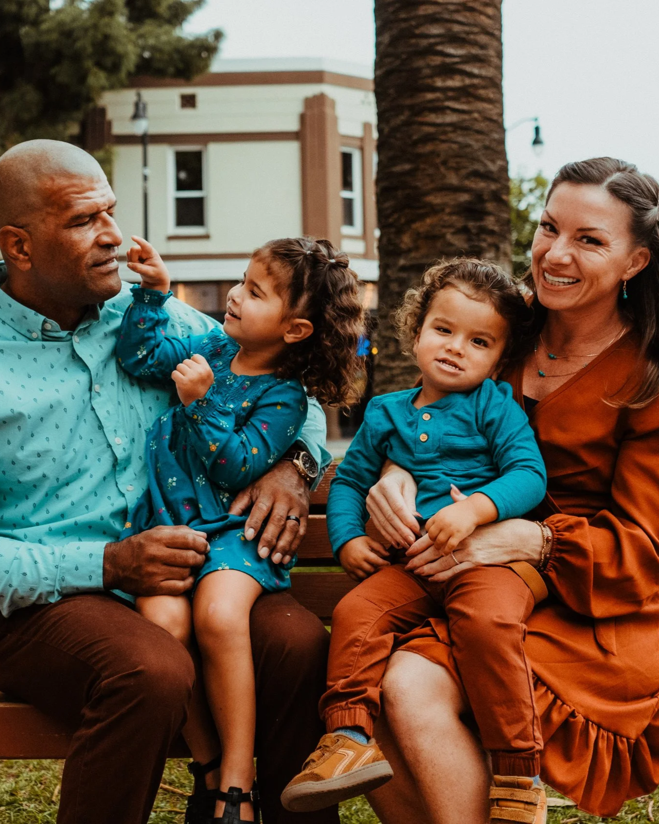 Erica on a park bench with her husband and their two children